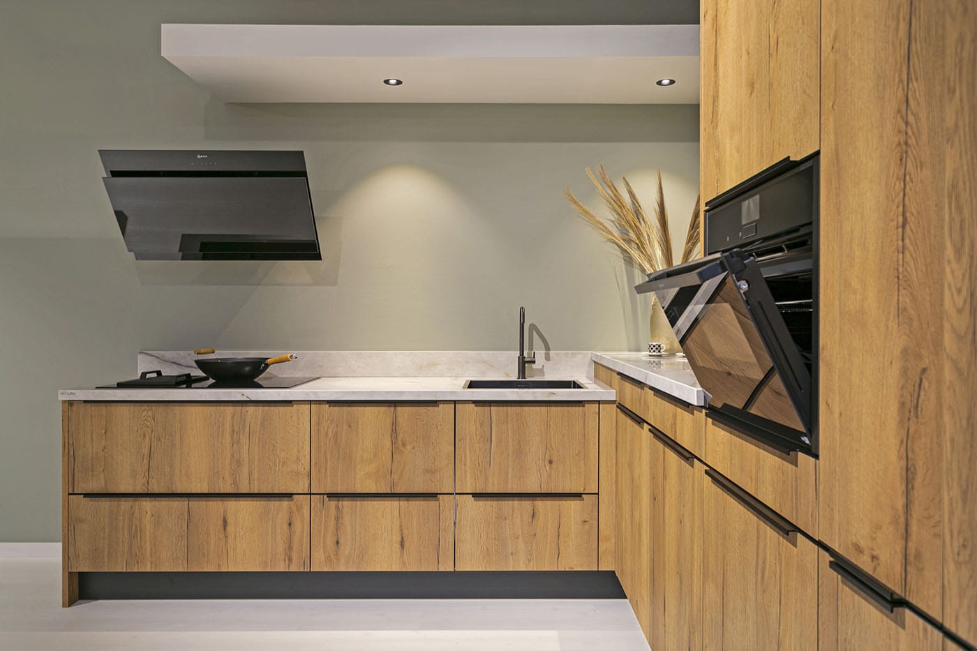 Keuken hout met design afzuigkap en zachtgroene muur