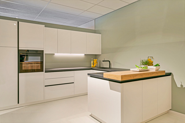 d' Achteromme Nieuwerkerk moderne keuken wit met donker blad, houten bar en zwarte kraan